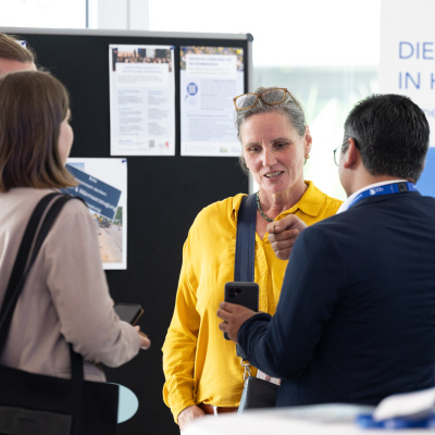 Personen im Gespräch an einem Stand