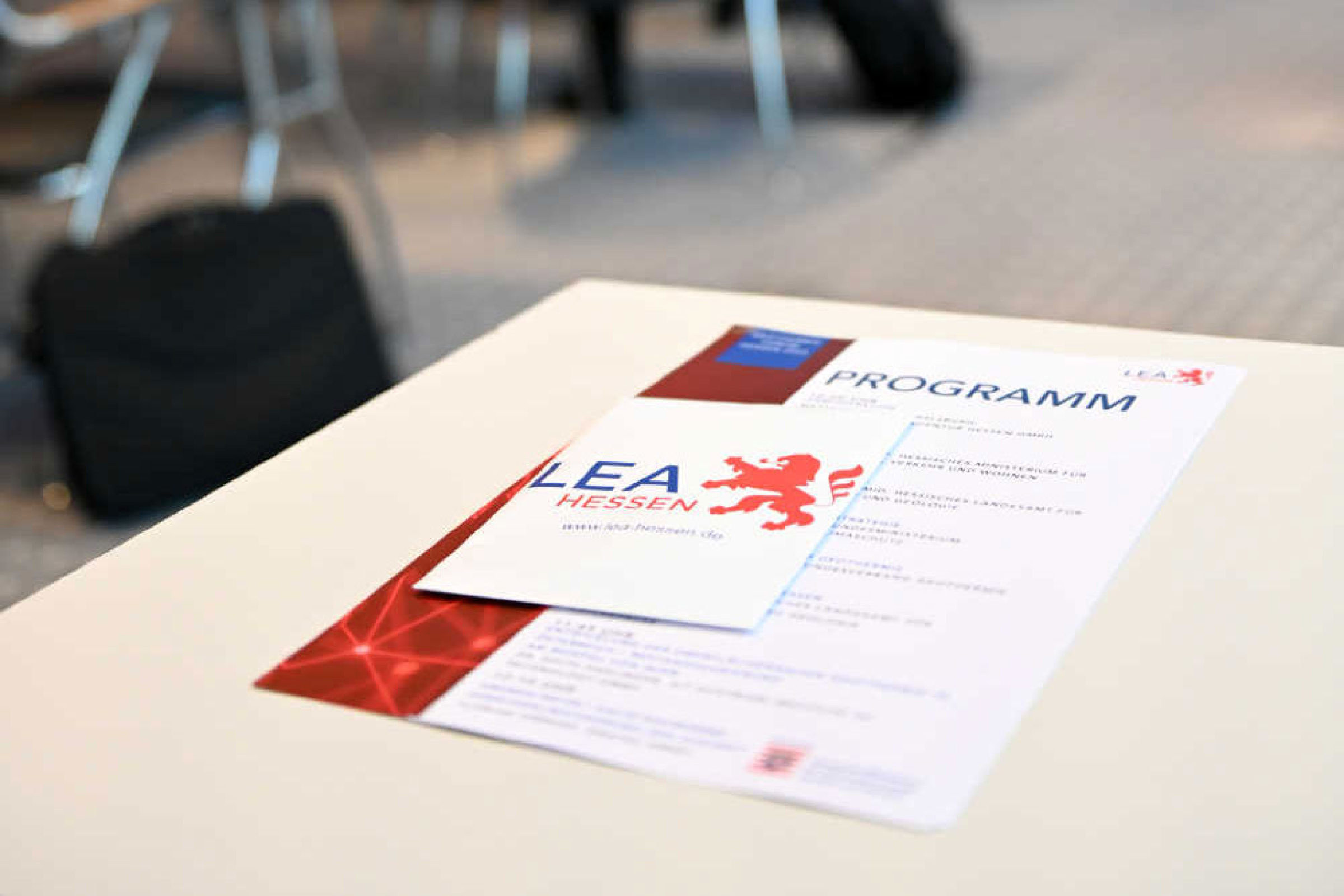 Geothermie-Forum 2022: Programmbroschüre LEA Hessen Eine Broschüre mit der Aufschrift "LEA Hessen" und ein Blatt mit der Aufschrift "Programm" liegen auf einem Tisch in einem Vortragssaal.