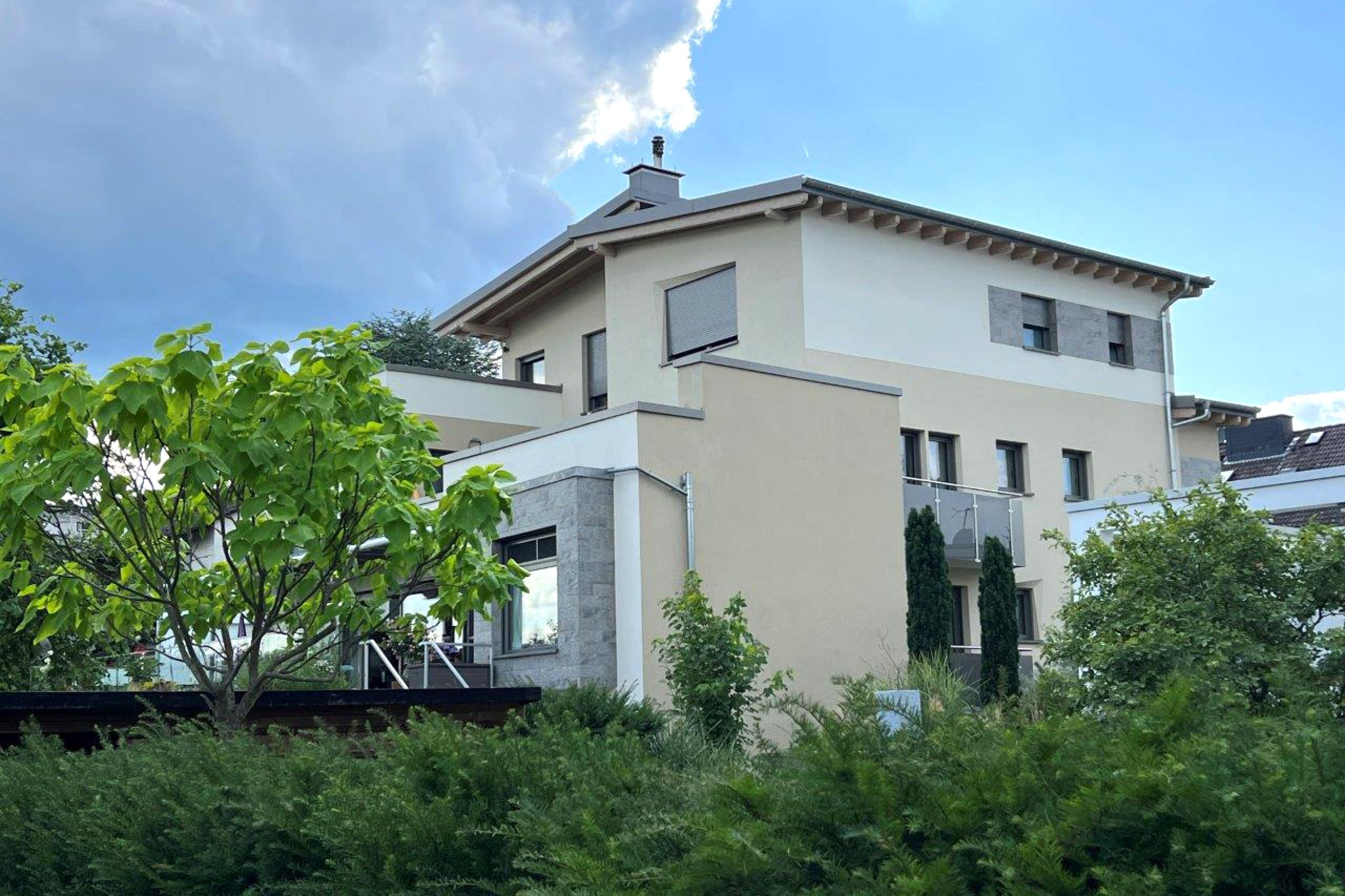 Seitliche Rückansicht des energetisch modernisierten Mehrfamilienhauses in WEG-Besitz der Familie Schinnenburg.