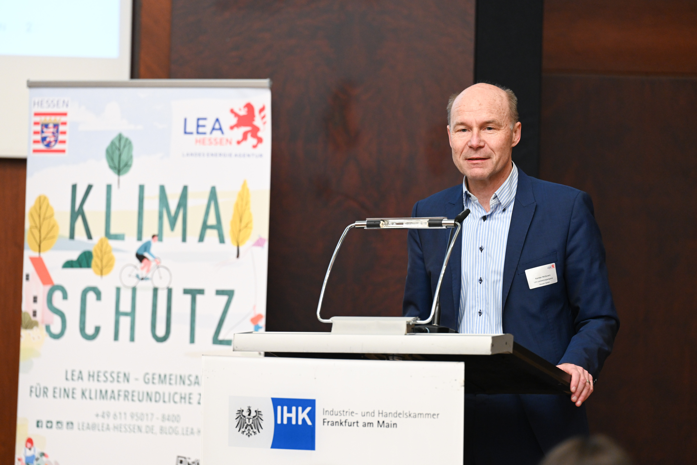 Regionaltreffen IEEKN 2023: Karsten McGovern am Rednerpult neben einem Klimaschutzposter.