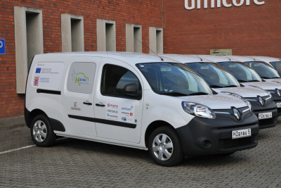 Mehrere wasserstoffbetriebene weiße Kleintransporter parken nebeneinander im Industriepark Hanau-Wolfgang.