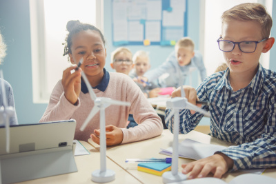 Eine Schülerinnen und Schüler hantieren im Unterricht mit einem Windrad-Modell