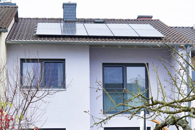 Rückansicht des Einfamilienhauses von Familie Hoffmann und Kallert in Dieburg, mit Balkon und Photovoltaik auf dem Dach.