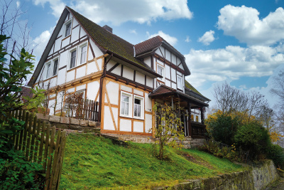 Frontalansicht der energieeffizienten Fachwerk-Doppelhaush&auml;lfte der Familie Lang.