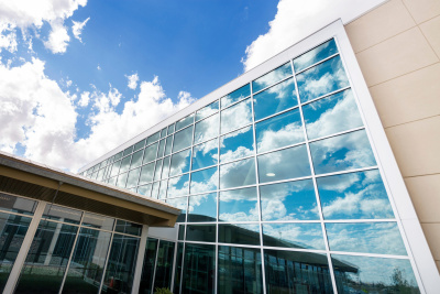 Modernes Krankenhausgebäude mit Glasfensterfront vor blauem Himmel
