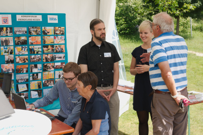 Gruppe im Freien umringt den Infostand des Bürgerforums in Bensheim.