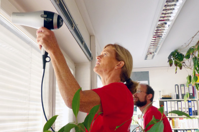 Frau föhnt Fensterfolien.