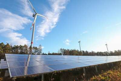 Solaranlage mit Windrädern im Hintergrund in Lützelbach/Odenwald Große Solaranlage im ehemaligen US-Munitionsdepot Hainhaus in Lützelbach. Hier wurde mit dem zweiten Bauabschnitt für die Errichtung der 2,1 Megawatt- Photovoltaik-Anlage begonnen. Im Hintergrund sind Windräder zu sehen.