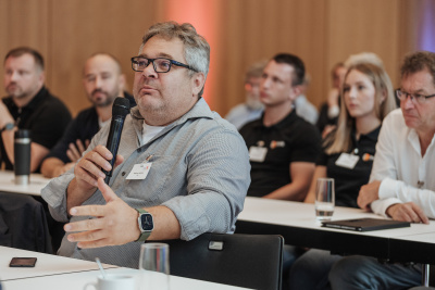 Mann sitzt am Tisch und spricht in das Mikrofon.