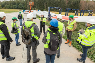 Baustellenbegehung einer Windkraftanlage in Ober-Ranstadt. Gruppe von Mneschen steht in Signalwesten und Helmen und hört einem Vortrag zu.