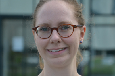 Portrait der Energie-, Klima- und Umweltschutzbeauftragten Mira Jana Stockmann. Sie trägt eine Brille, eine hellen Bluse und hat das Haar zurückgebunden.