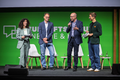 Moderatoren Duo auf der Bühne mit den Geschäftsführern von der LEA Hessen und deENet e.V.