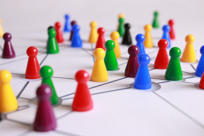 Netzwerk: Mehrere bunte Spielfiguren stehen auf einer weißen Fläche mit Verbindungslinien.