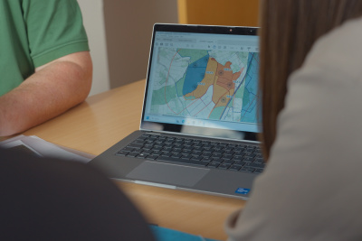 Personen vor einem Computer mit einem Flächenplan