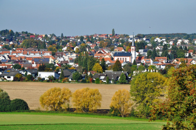 Blick auf die Stadt Roßdorf bei Darmstadt mit Bäumen und Felder im Vordergrund.