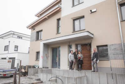 Das Bild zeigt eine Familie vor ihrem energetisch sanierten Haus.