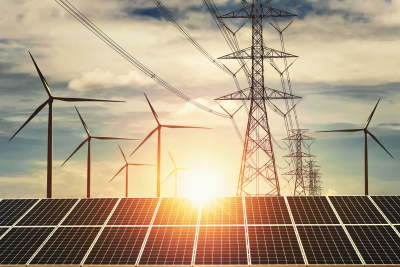 Windr&auml;der, Strom-&Uuml;berlandleitungsmasten und Solarkollektoren vor untergehender Sonne.