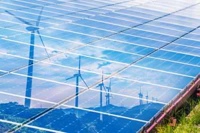 Windräder spiegeln sich in Solarkollektoren-Park