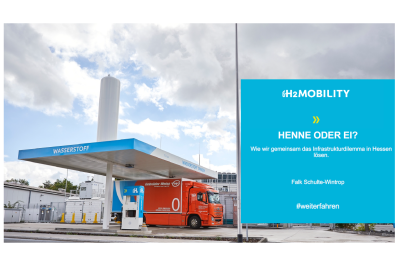 Folie des Vortrages "H2-Mobility: Henne oder Ei?" mit Abbildung einer Wasserstofftankstelle, an der ein roter LKW steht.