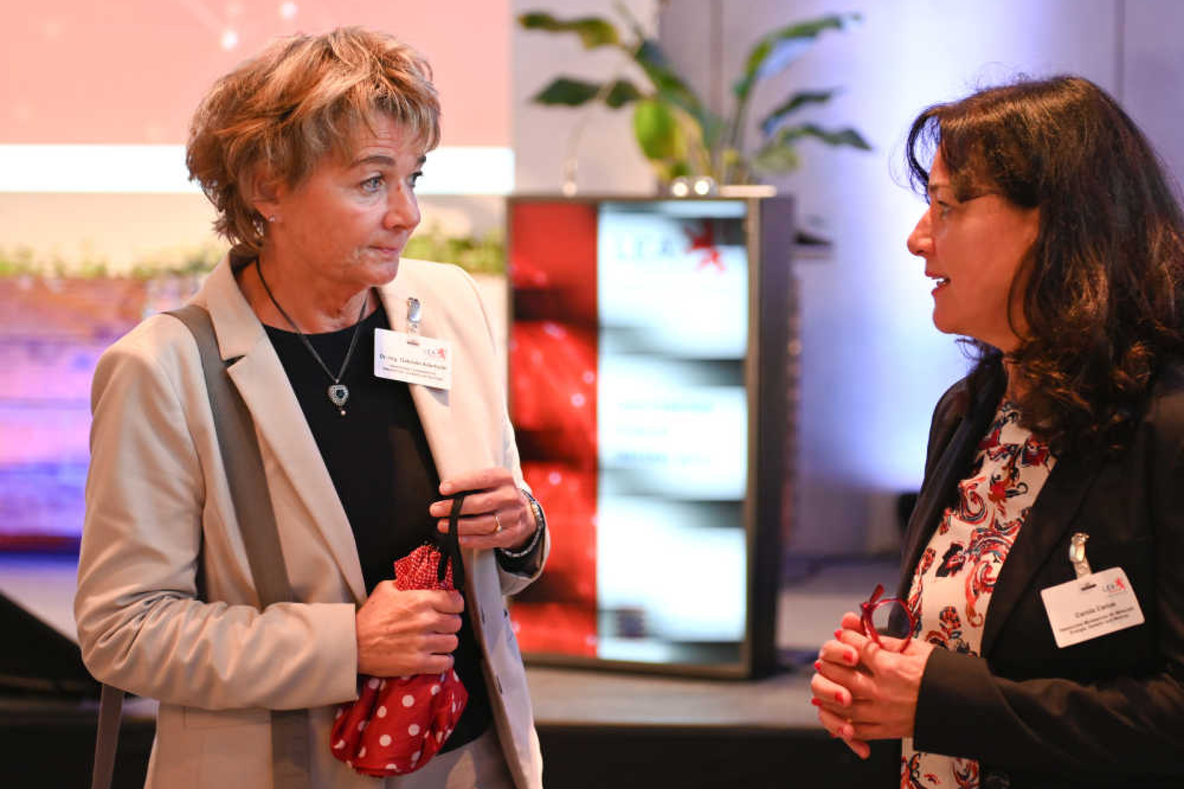 Geothermie-Forum 2022: Zwei Damen im Gespräch Zwei Frauen stehen in einem Sitzungssaal und unterhalten sich.