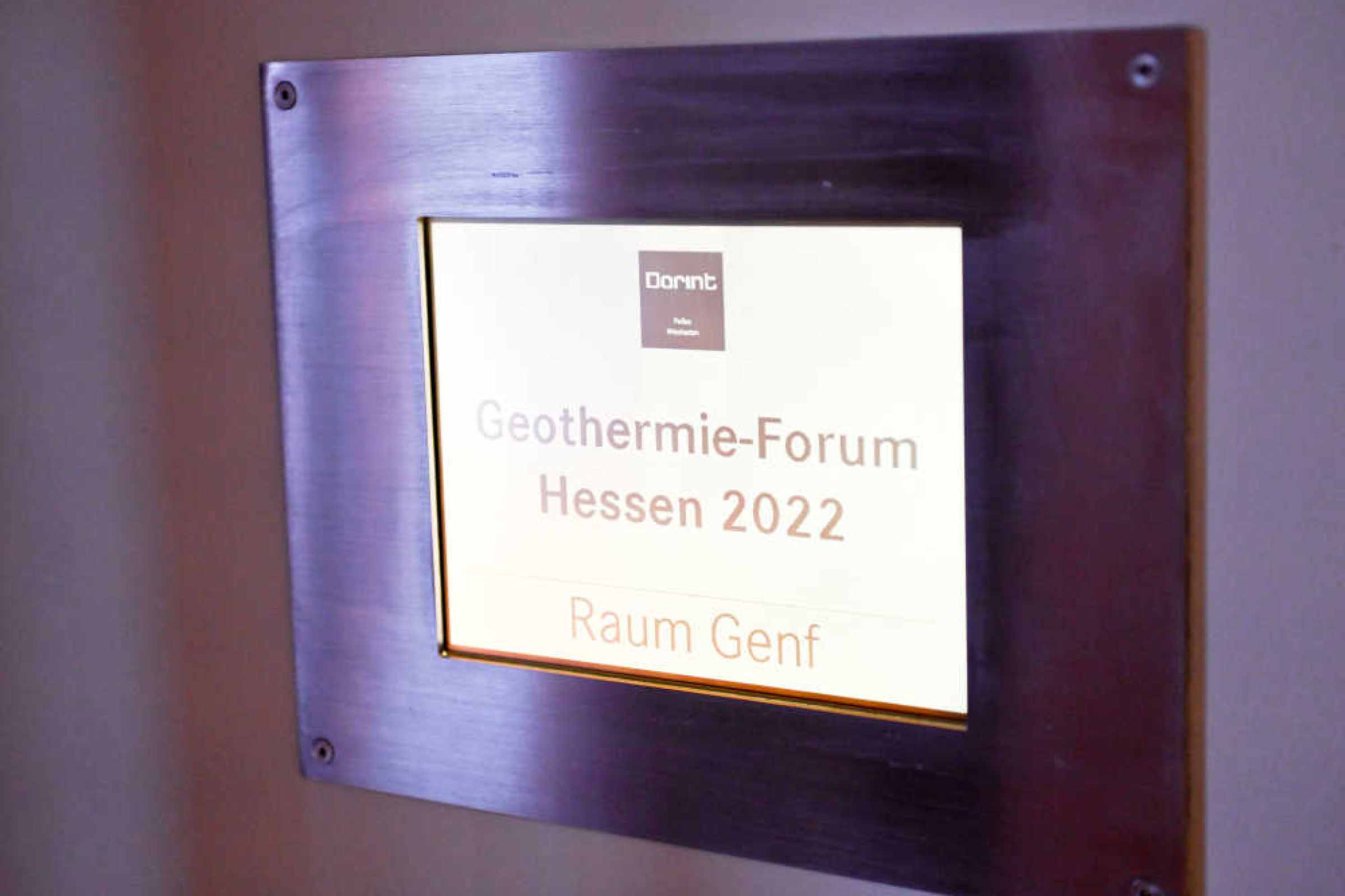 Geothermie-Forum 2022: Schild am Vortragssaal Schild mit dunklem Rahmen, Aufschrift: "Dorint – Geothermie-Forum Hessen 2022, Raum Genf"