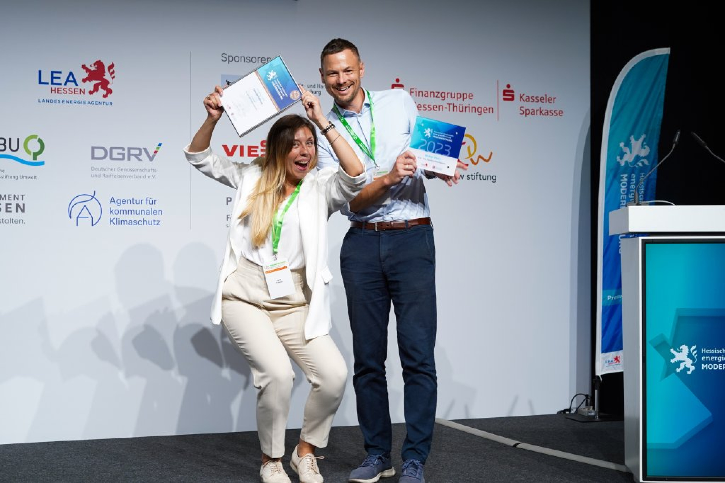 Familie Folkens posiert freudestrahlend auf der Bühne mit Urkunde und Scheck.