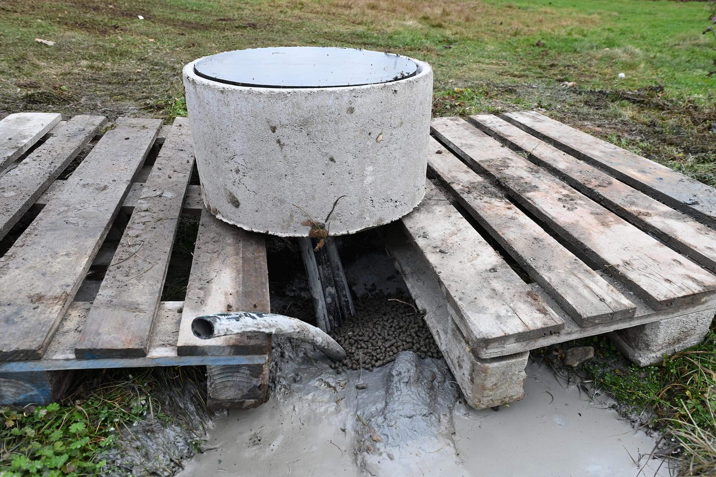 Geothermie Probebohrung Frankfurt-Rebstock: Zwei Holzpaletten liegen nebeneinander auf dem Boden, auf ihnen steht eine Art Kübel.