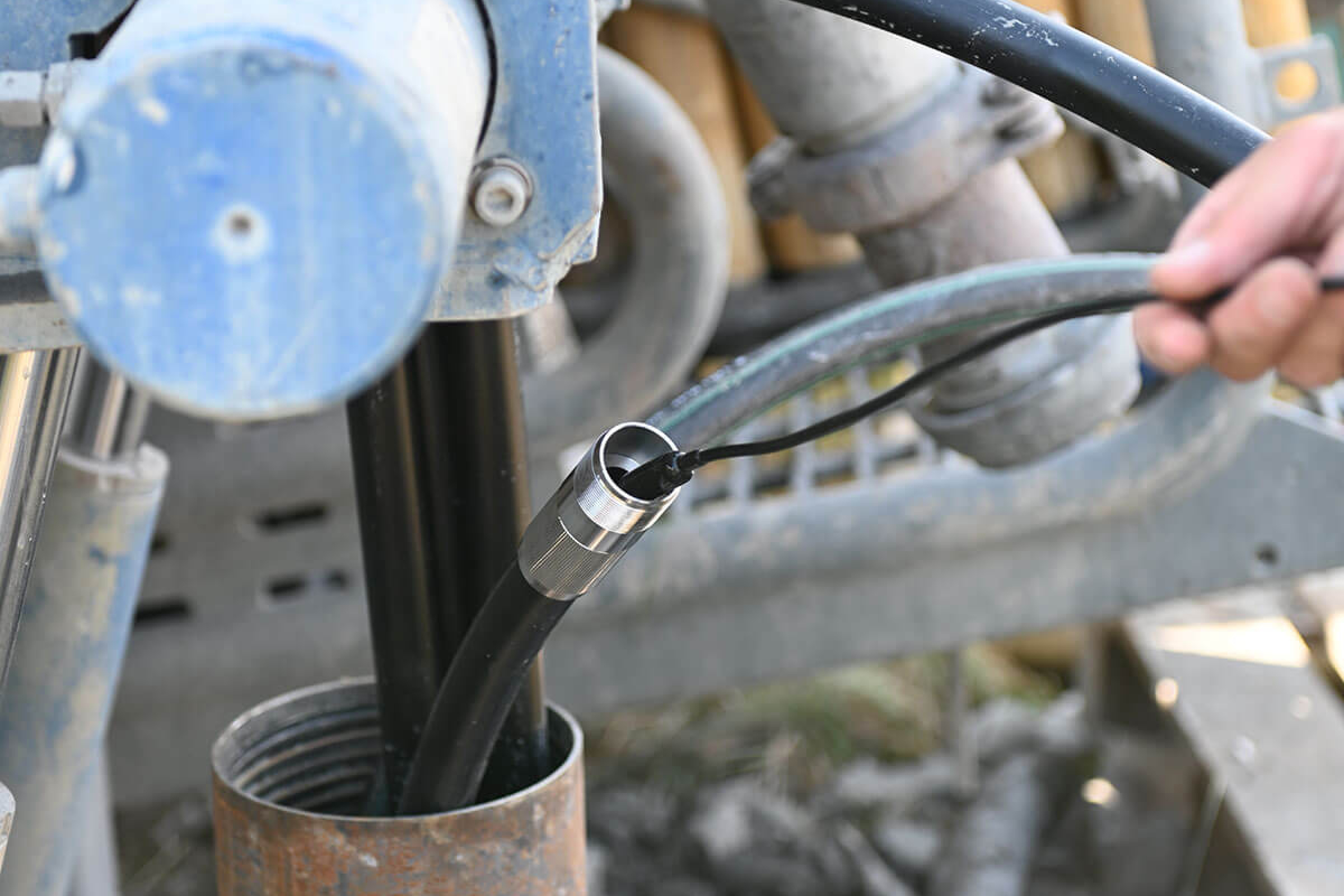 Geothermie Probebohrung in Stockstadt am 14.09.2021, Mann hält einen Schlauch an der Bohrmaschine.