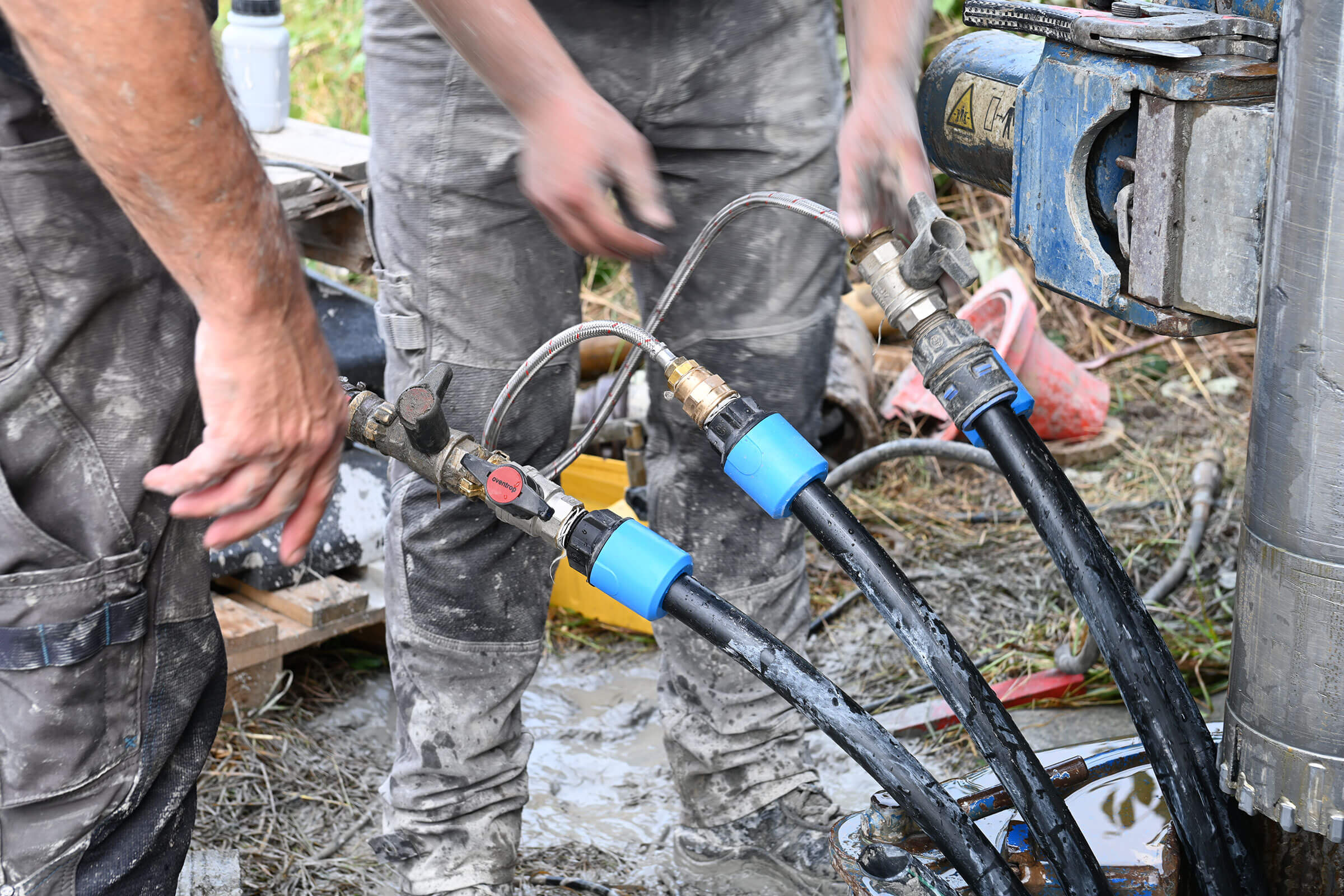 Geothermie: Probebohrung in Stockstadt am 14.09.2021, Männer arbeiten an Schlauchanschlüssen.