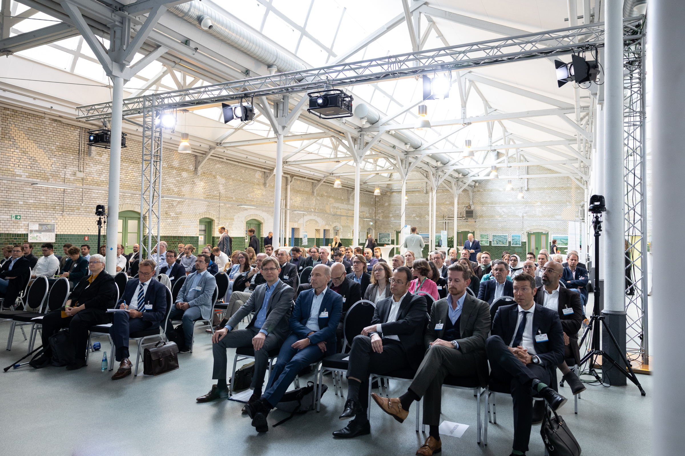 Brennstoffzellenforum 2022 Brennstoffzellenforum 2022, Zuschauerraum in einer Halle mit Oberlichtern.