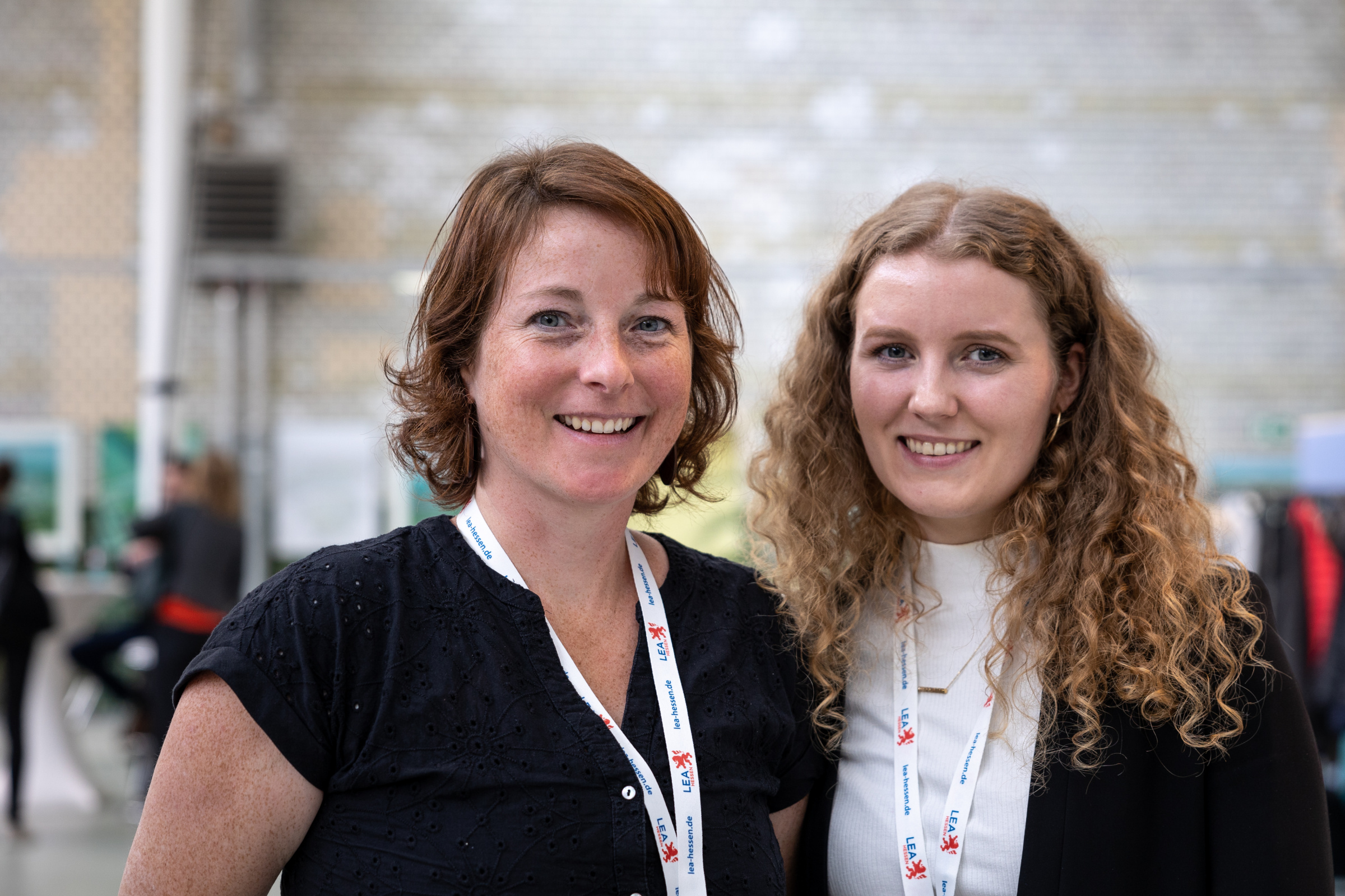 Brennstoffzellenforum 2022 Zwei Frauen stehen nebeneinander auf einer Ausstellung und lächeln in die Kamera.