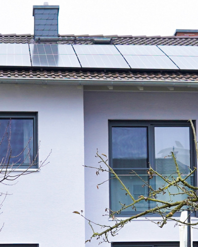 Rückansicht des Einfamilienhauses von Familie Hoffmann und Kallert in Dieburg, mit Balkon und Photovoltaik auf dem Dach.