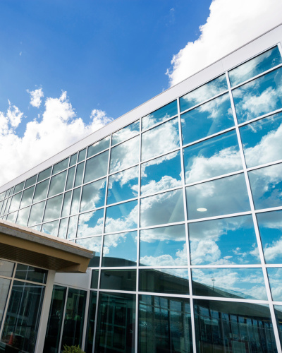 Modernes Krankenhausgebäude mit Glasfensterfront vor blauem Himmel