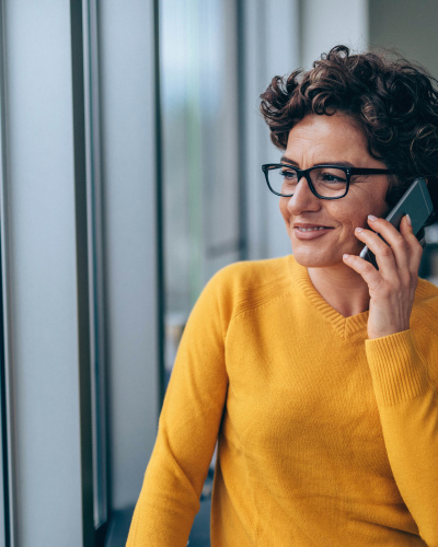 Frau erhält Beratung am Telefon Eine Frau im Büro erhält eine telefonische Beratung