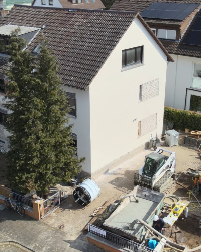 Geothermie-Bohrung neben einem Einfamilienhaus in einer Siedlung.