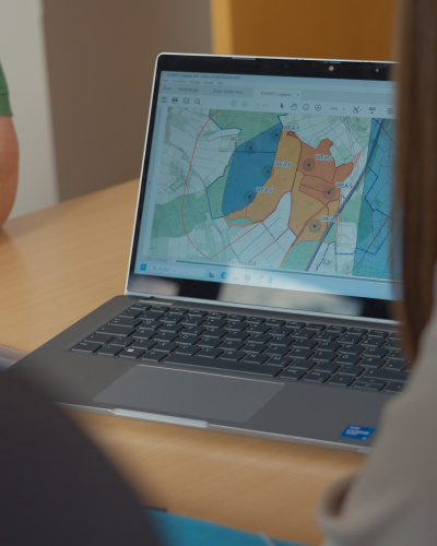 Personen vor einem Computer mit einem Flächenplan