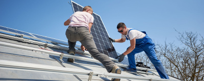 Zwei Handwerker installieren eine Photovoltaikanlage