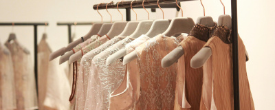 Kleiderstange mit Kleidung in hellen Farben