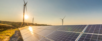 Photovoltaikanlage auf Freifl&auml;che mit Windkraft im Hintergrund