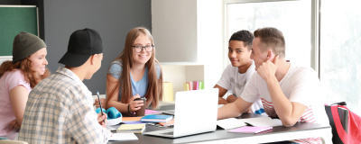 Eine Schülergruppe im Teenageralter beim gemeinsamen Lernen und Erarbeiten.