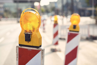 Baustelle mit Warnleuchten auf Radweg.