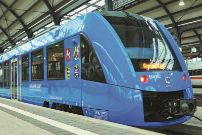Wasserstoff: Zug im Bahnhof Blauer Zug mit Wasserstoffantrieb steht in einem überdachten Bahnhof.